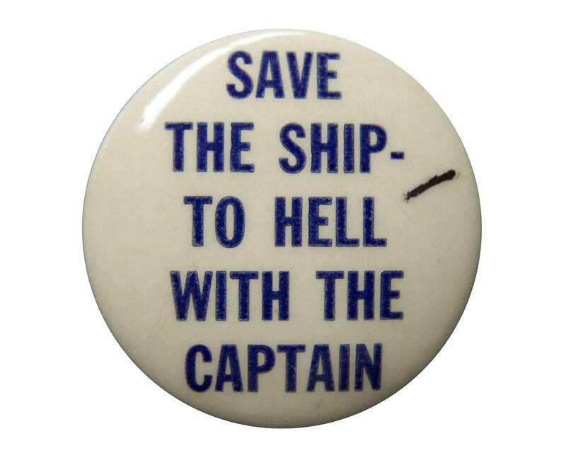 A round pinback slogan button. Blue text on a white background reads: