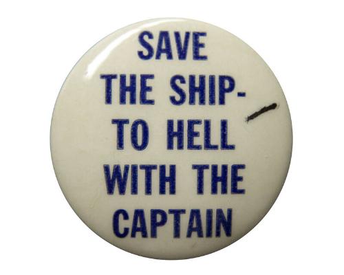 A round pinback slogan button. Blue text on a white background reads: